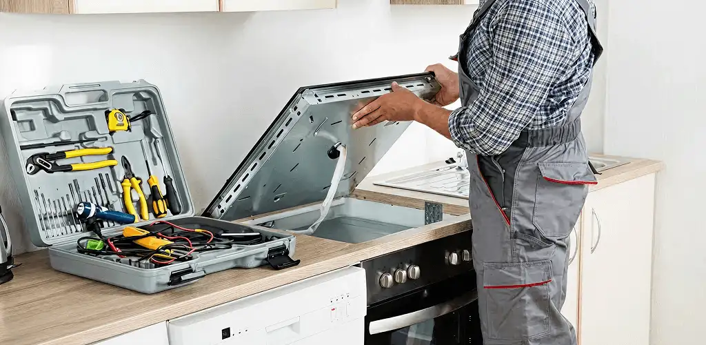 Handyman repairing a cooktop and checking wiring connections in Mesa, AZ