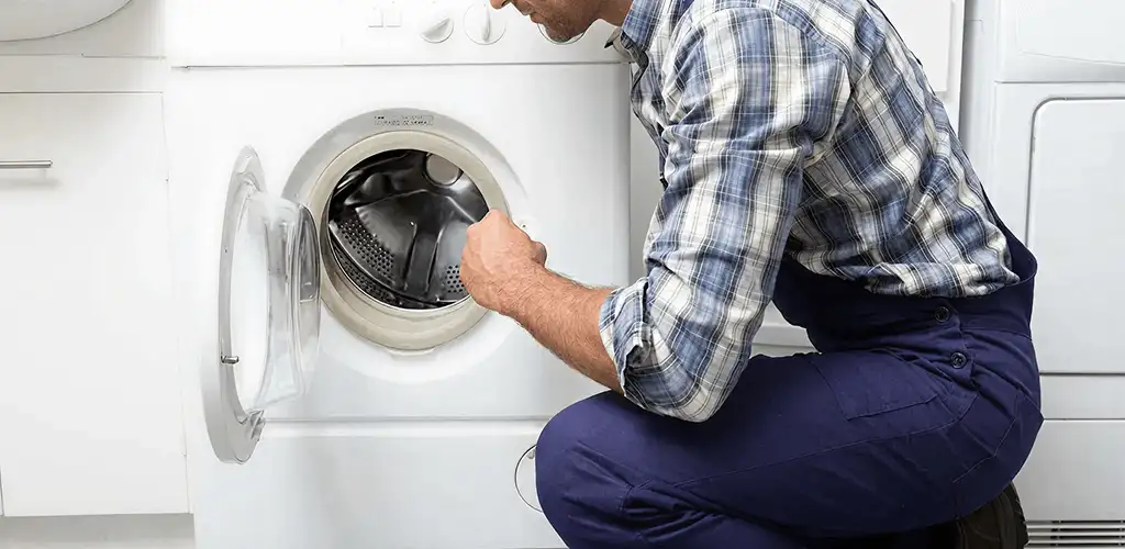 Handyman inspecting a dryer drum and internal parts for repair in Mesa, AZ