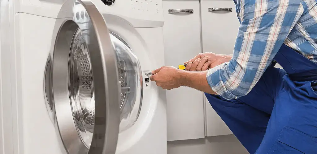Handyman repairing a clothes dryer and checking electrical connections in Mesa, AZ