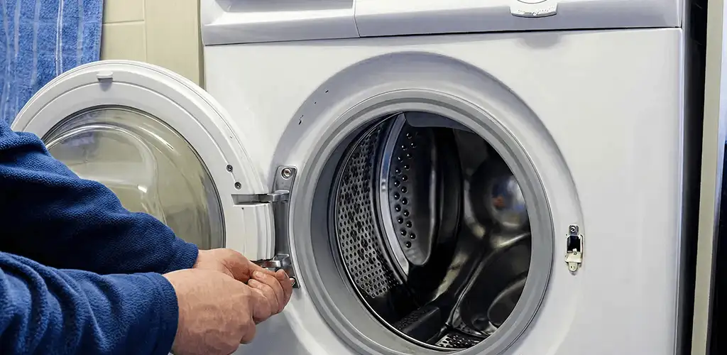 Washing machine repair handyman checking a front-load washer door and latch in Mesa, AZ