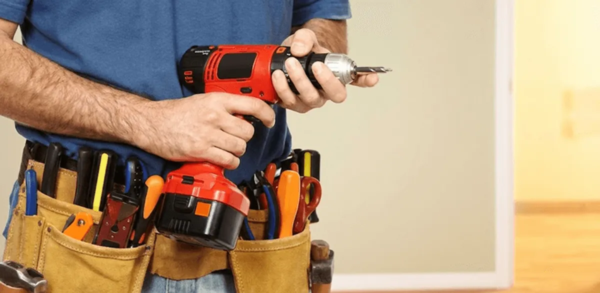 Handyman holding a power drill for home repairs and installations in Mesa, AZ