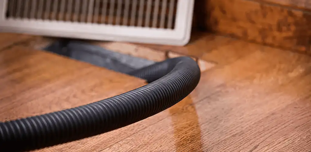 Air duct cleaning hose inserted into a floor vent for ductwork cleaning in Mesa, AZ