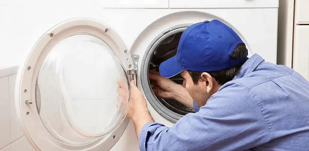 Washing machine repair handyman inspecting a front-load washer drum in Mesa, AZ
